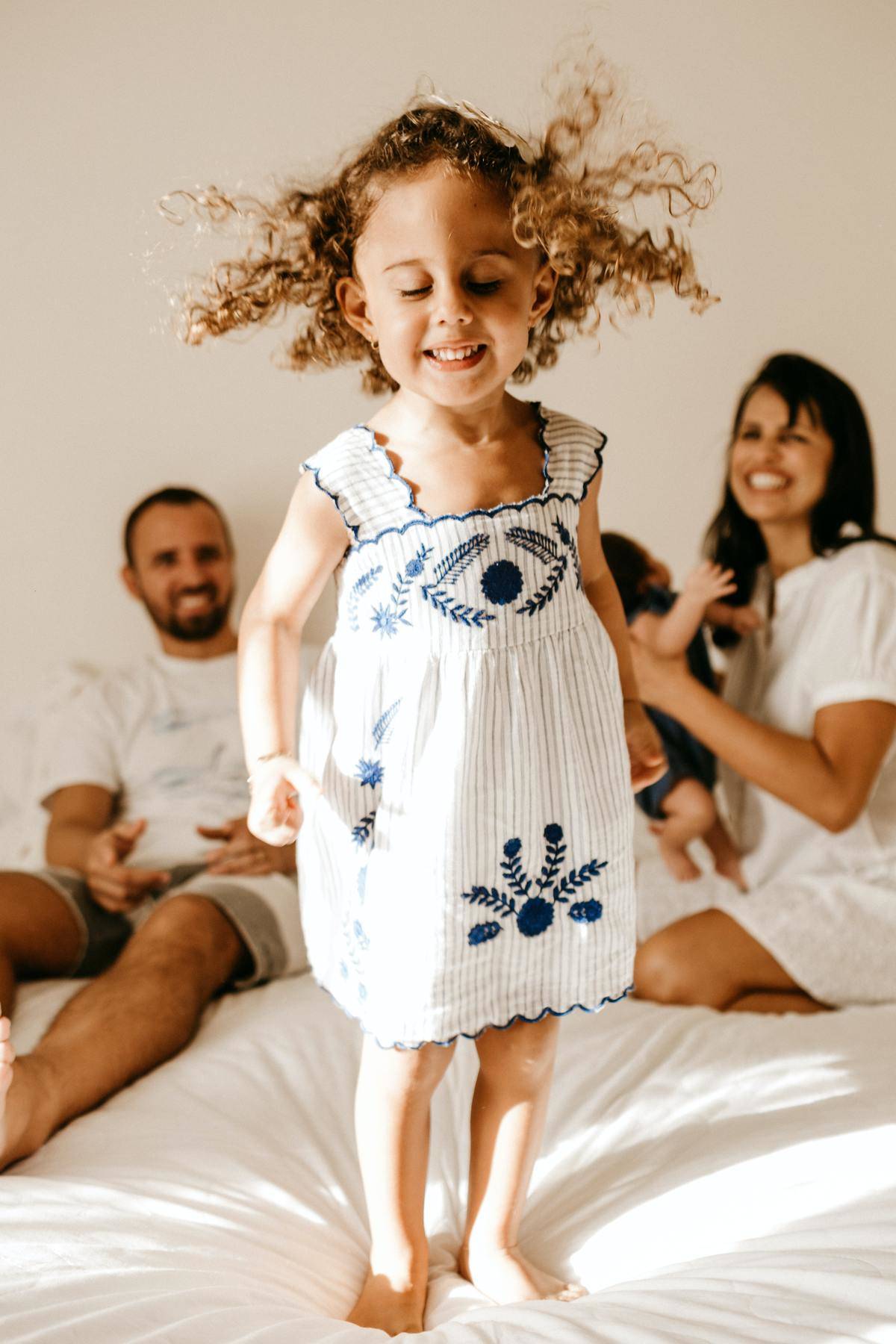 parents on bed smiling with daughter