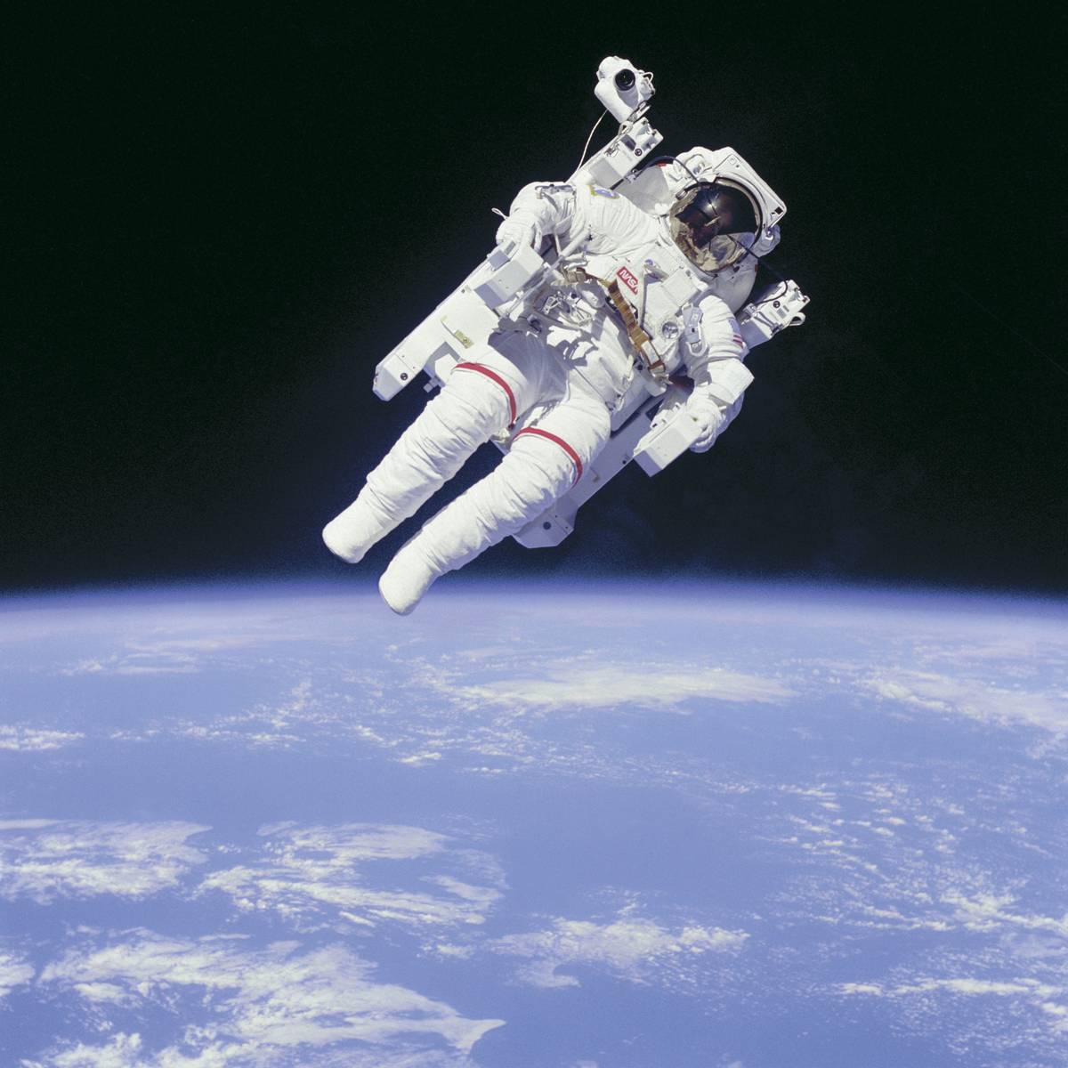 A NASA astronaut floats in space above the Earth.
