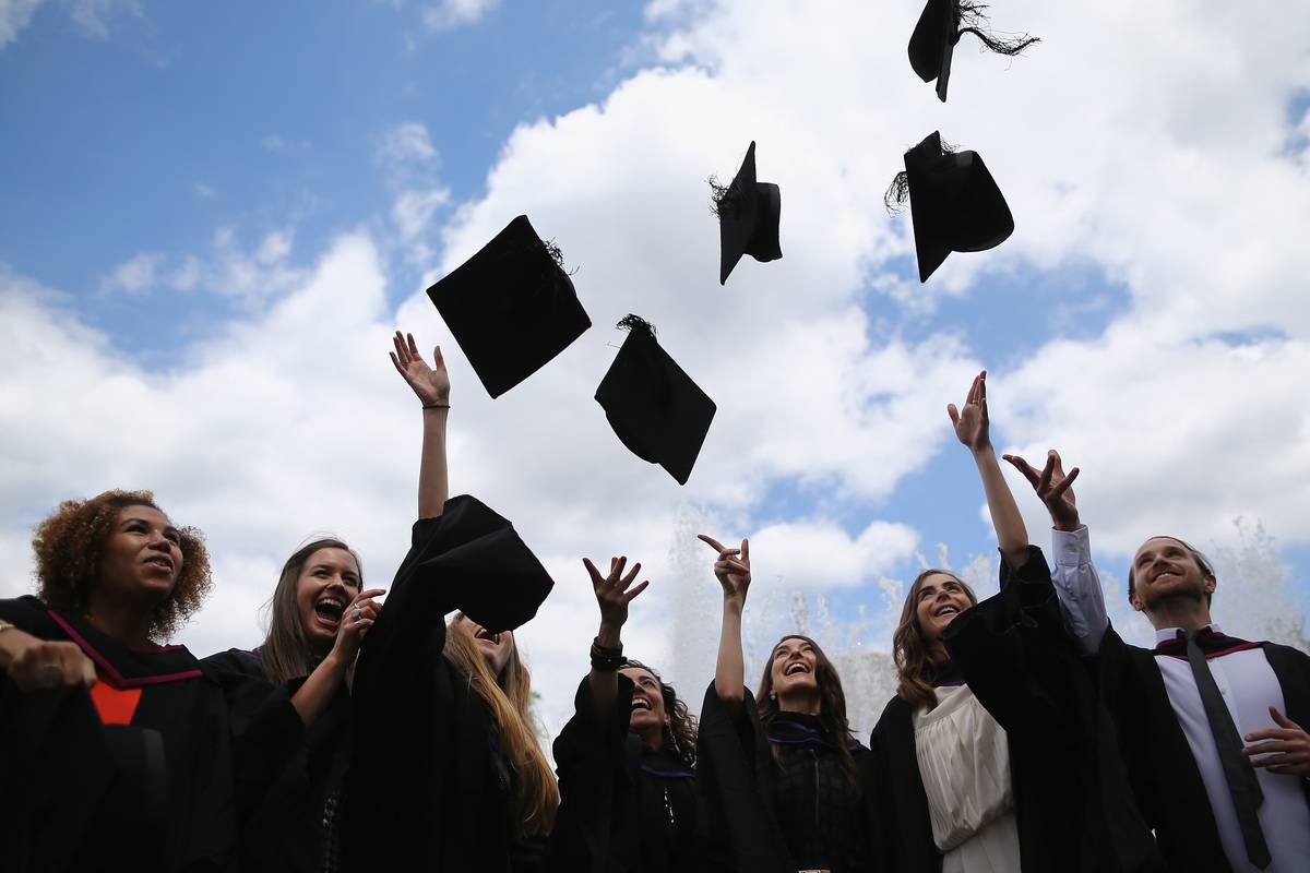 University graduates throw their caps in the air in celebration.