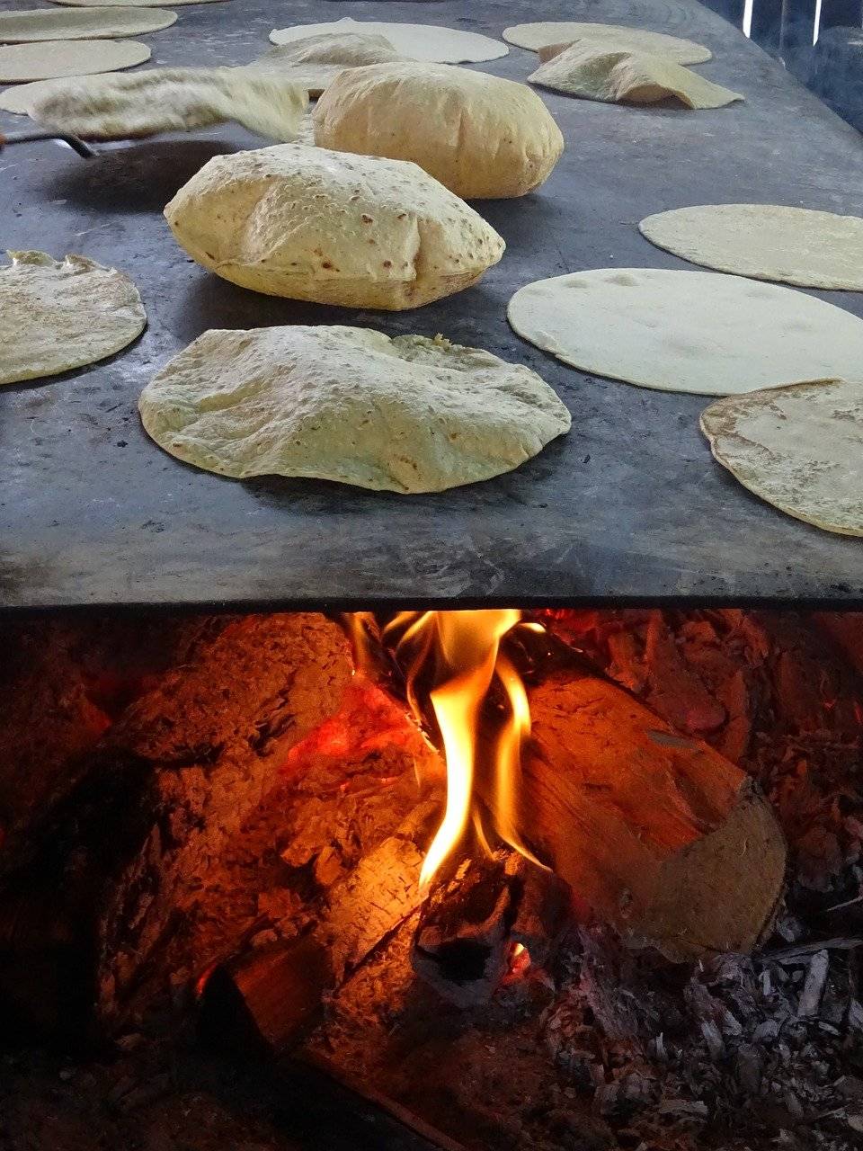 Tortillas are warmed on a stovetop above a fireplace.
