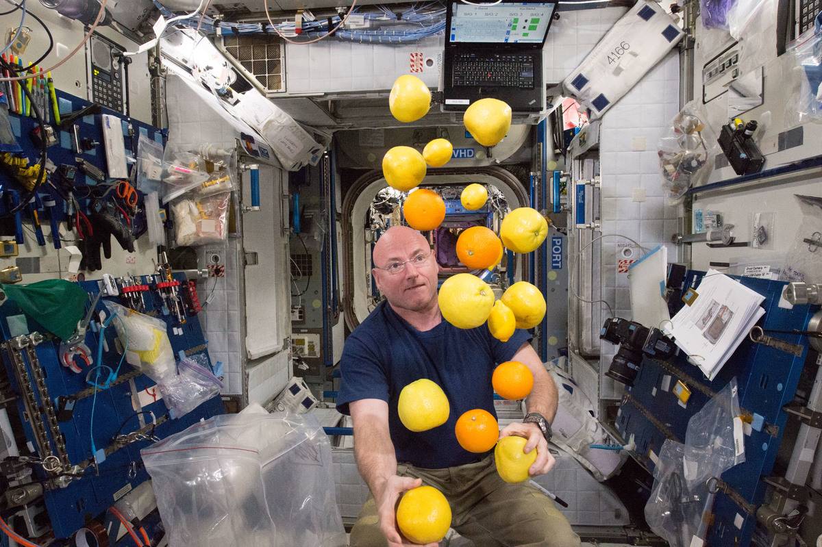In this International Space Station, Scott Kelly juggles fresh fruit that arrived for his crew.