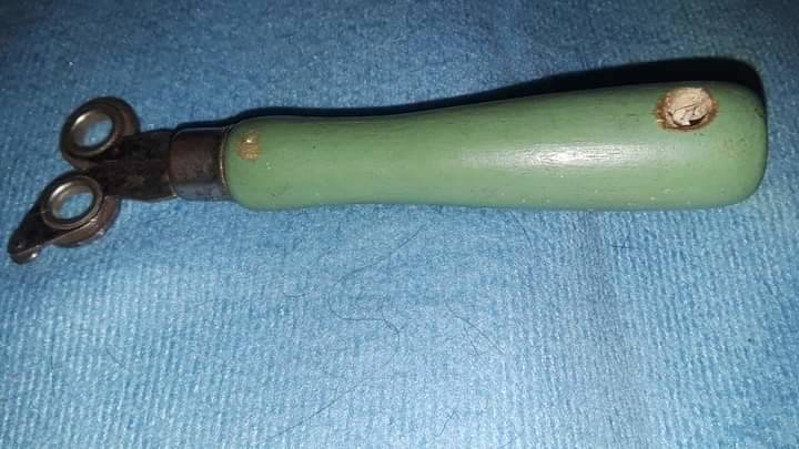 green wooden tool with circular metal attachments