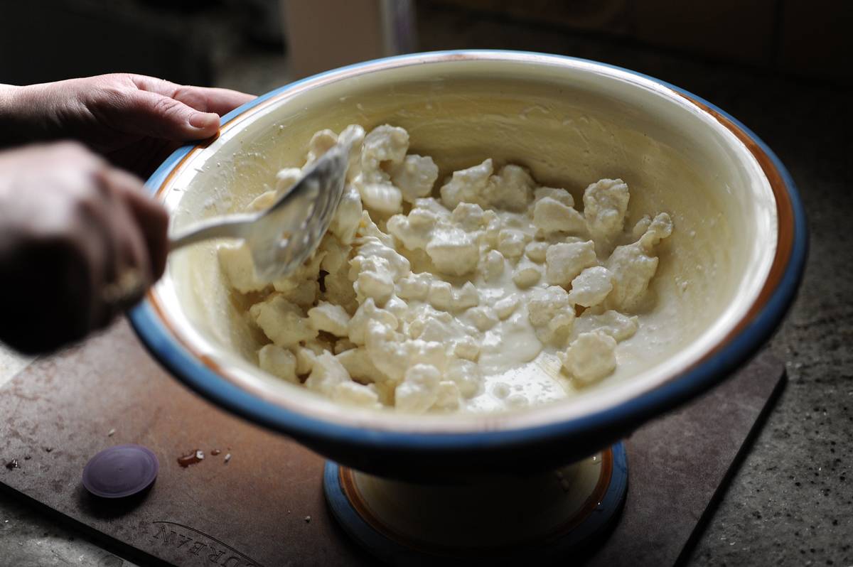 A person stirs around cottage cheese.