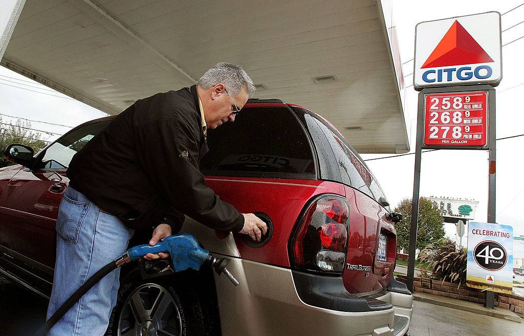 a man pumping gas at a gas station