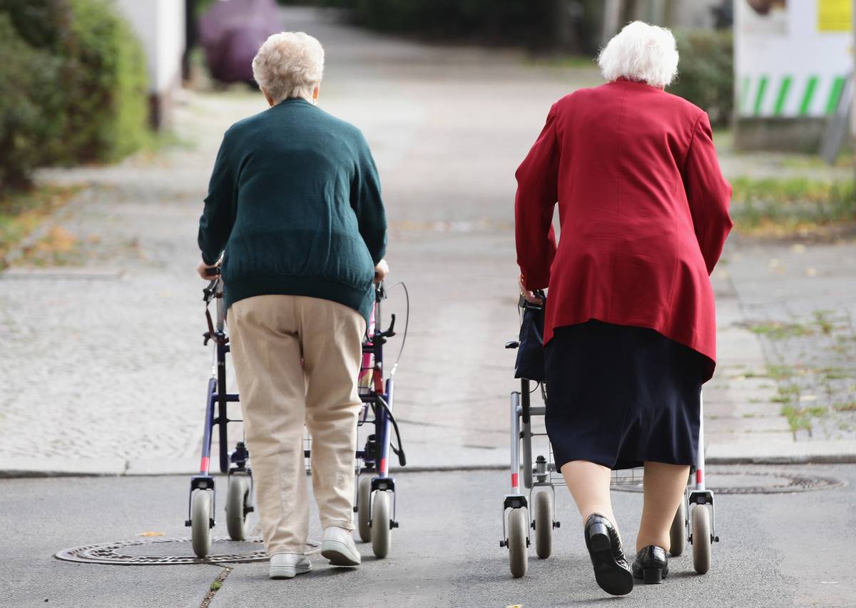 Retired women walk together with shopping carts.