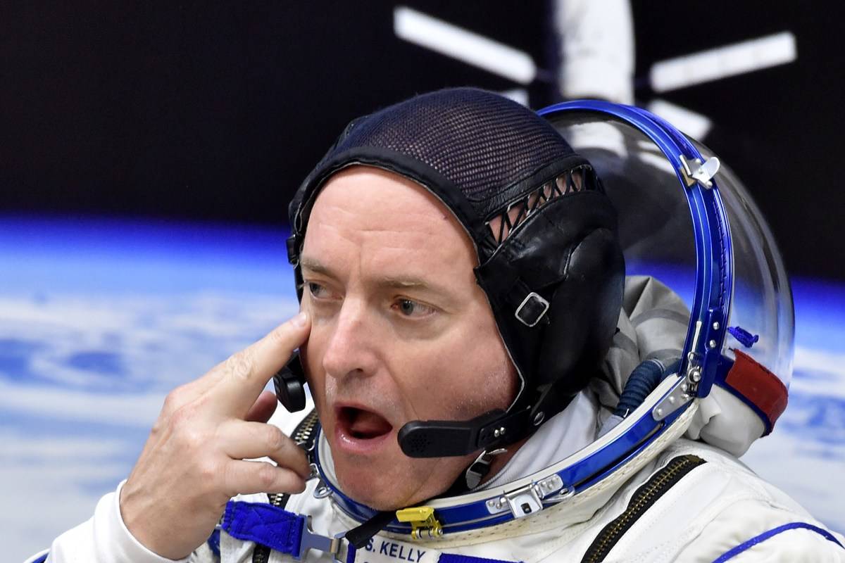 Scott Kelly rubs his eye as his space suit is being tested.