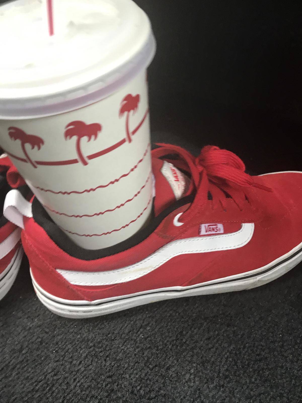 a red Vans shoe holding an in n out cup
