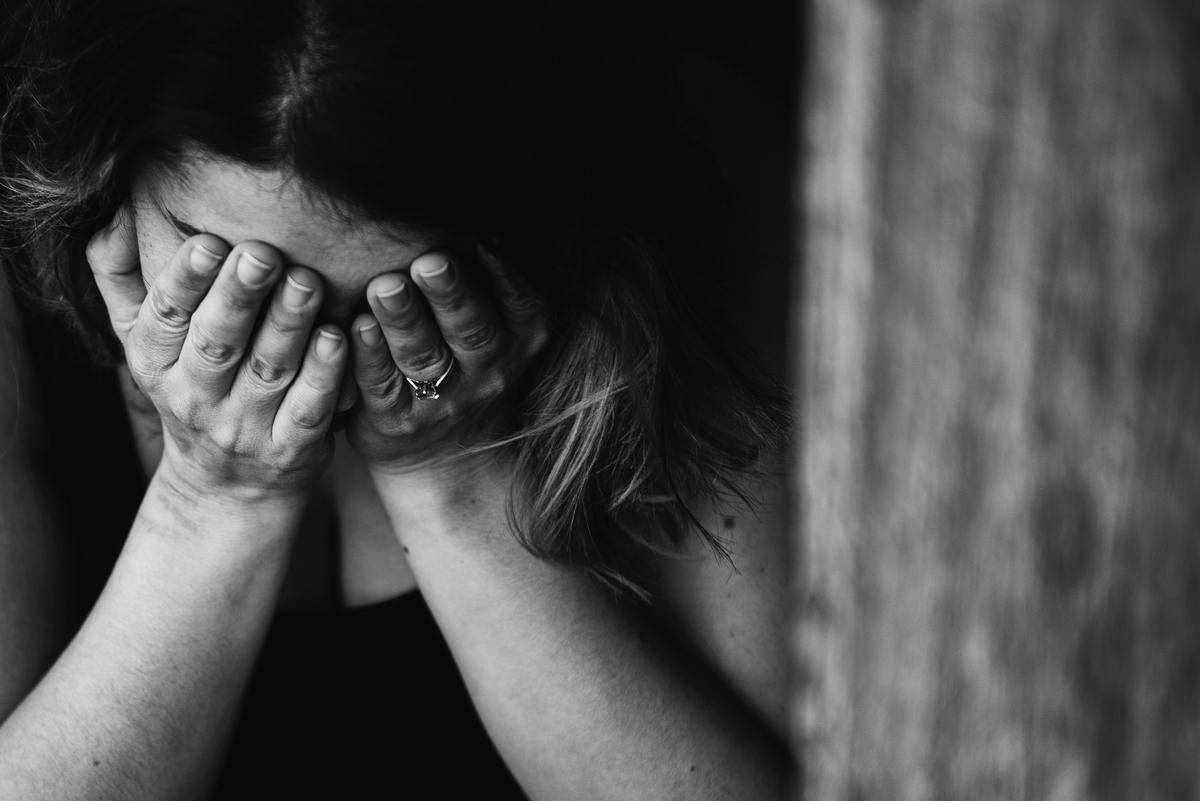 woman with head in hands upset
