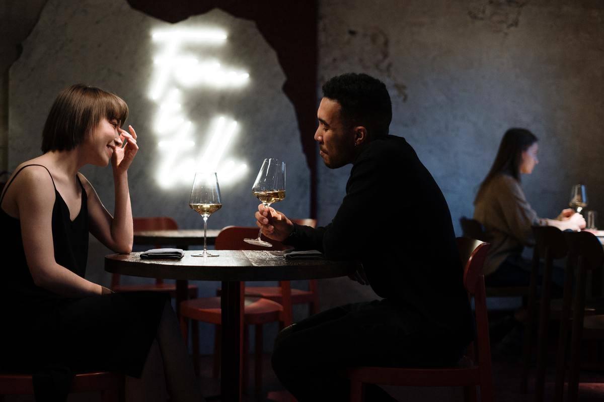woman and man have wine at bar