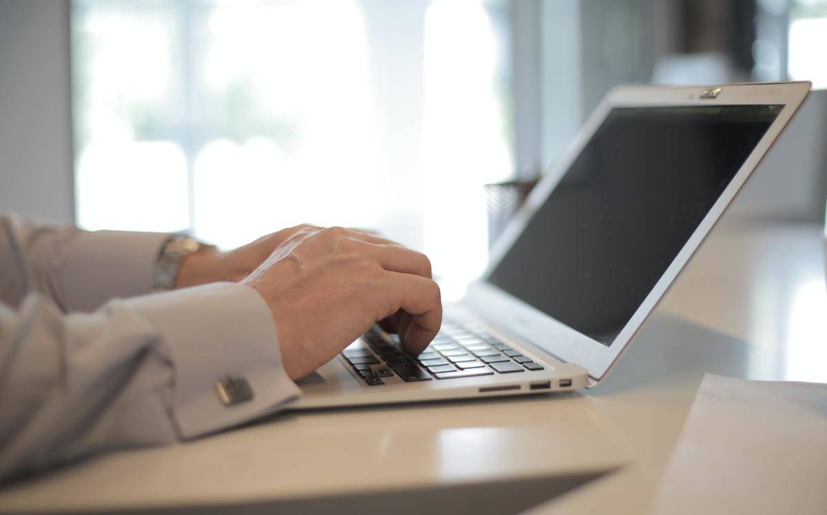 Man sits typing on laptop