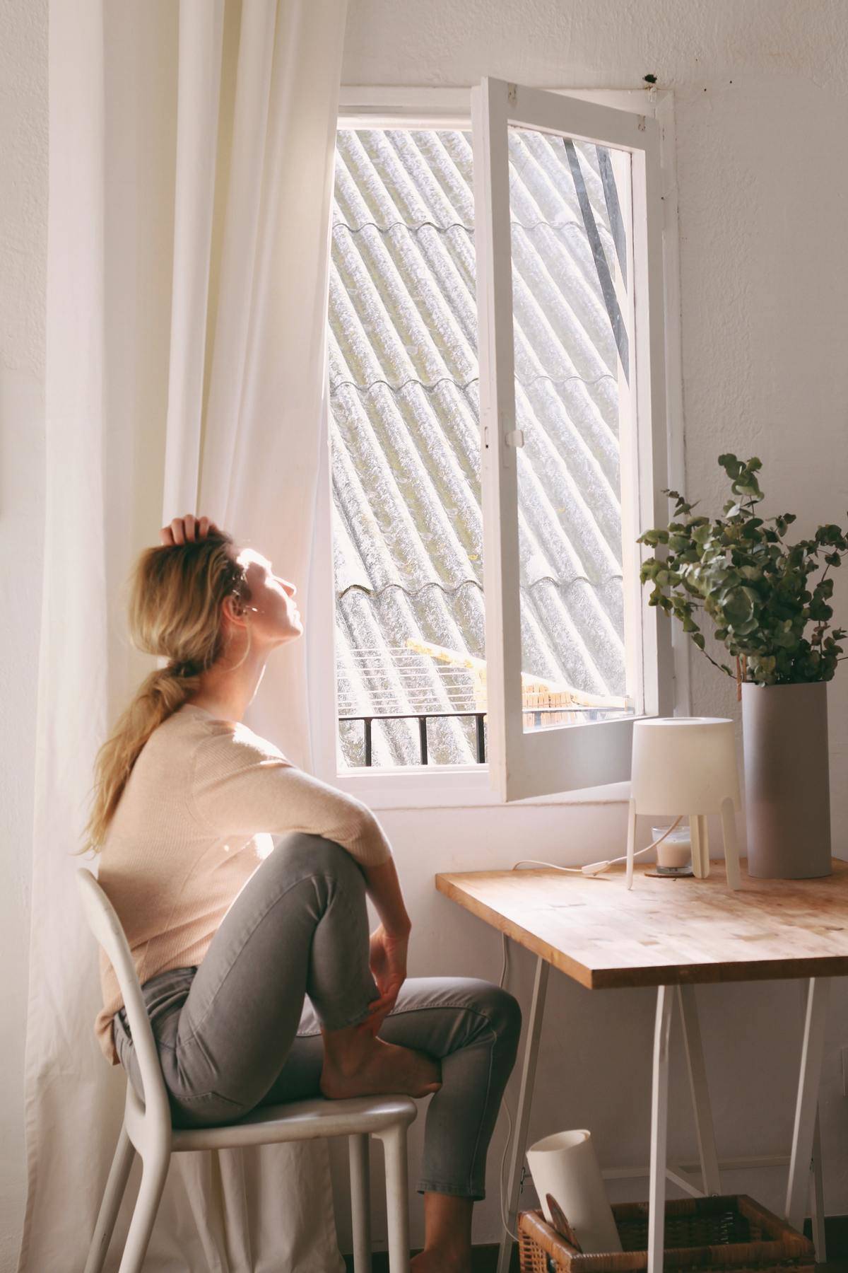 Woman stares out window looking tired or upset