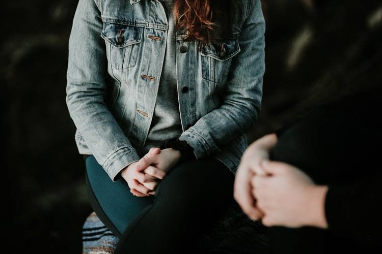 photograph of two people's hands resting on their laps