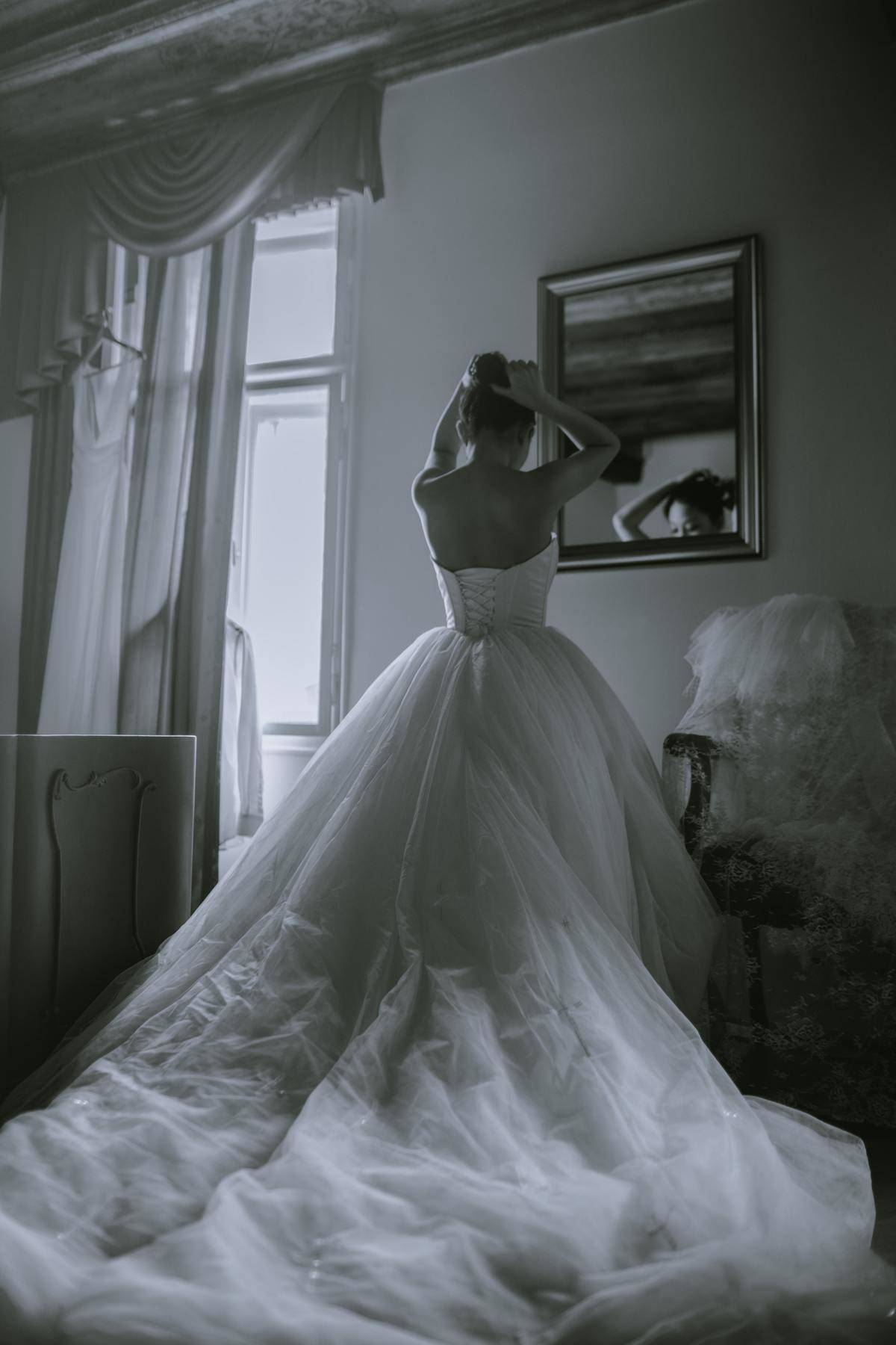 woman looking in mirror in ball gown