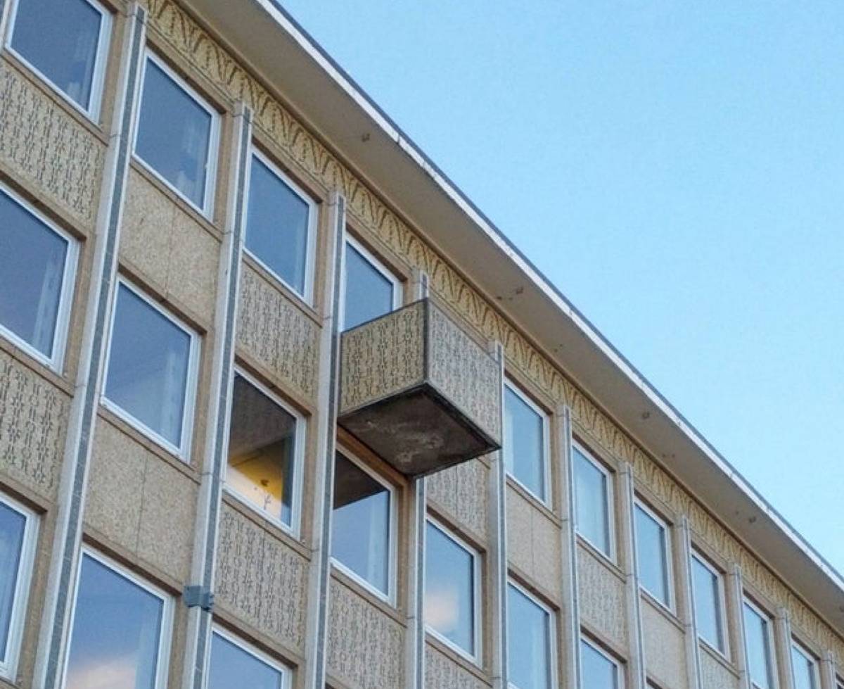 random box shaped object attached to the exterior of a building 