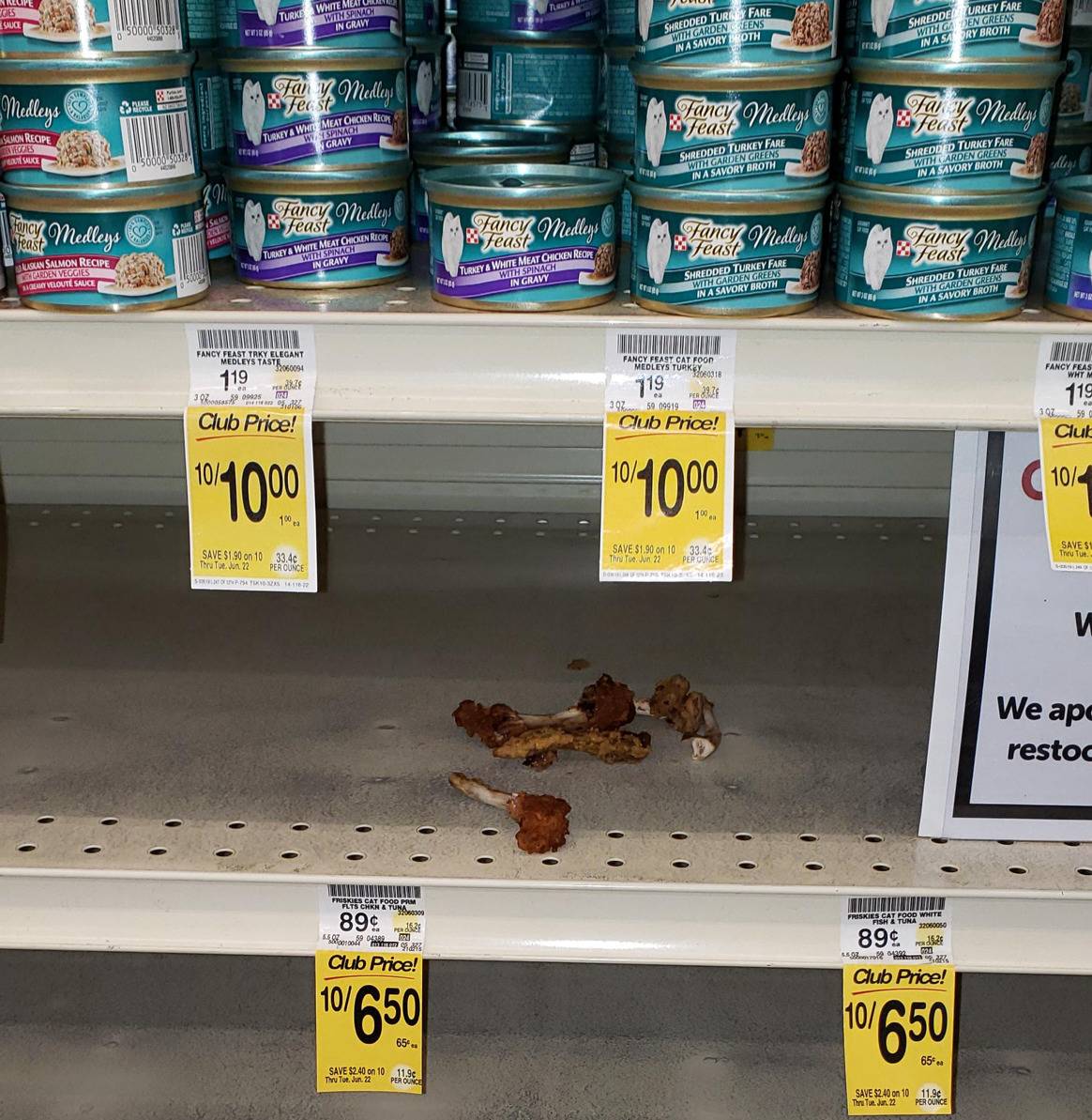 empty grocery store shelf with a few chewed chicken bones on it 