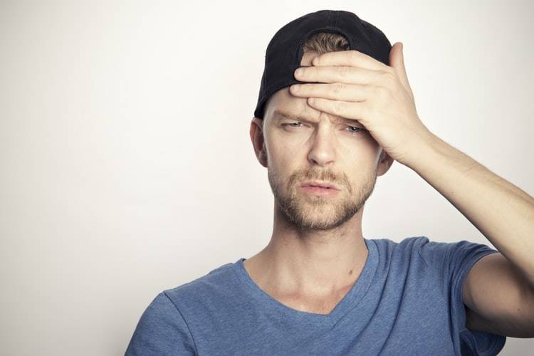 man in baseball cap with confused expression on his face