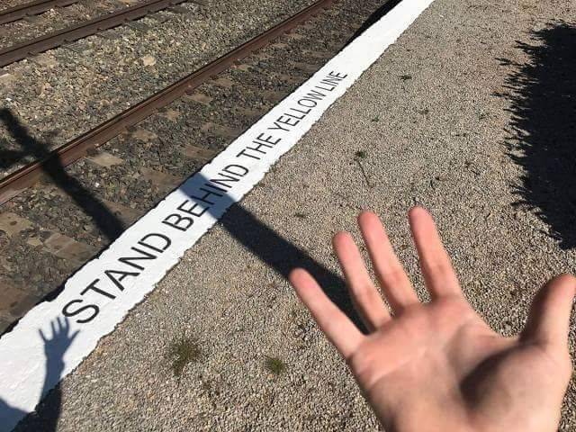 stand behind yellow line written on white line
