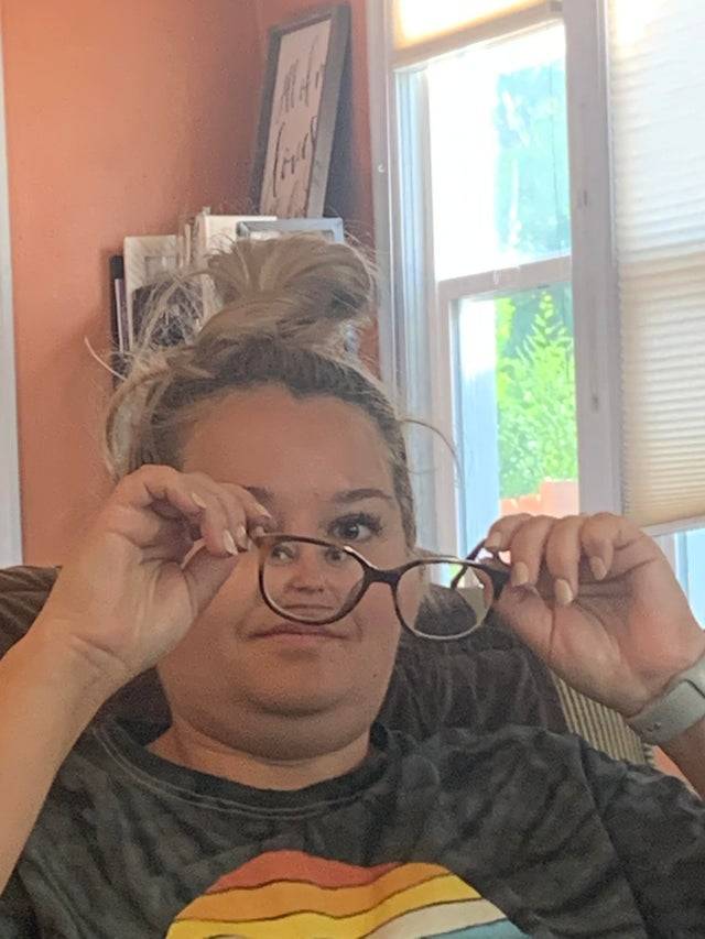 photo of woman putting on glasses