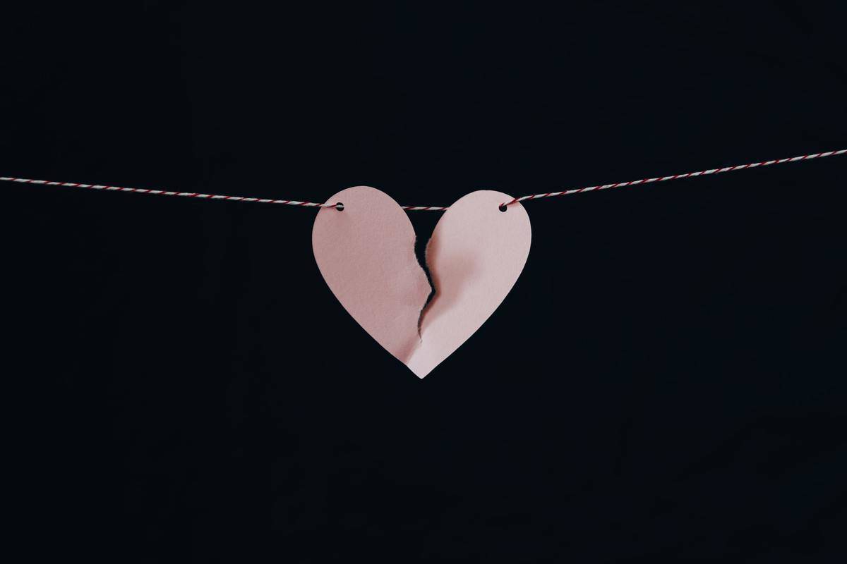 Heart made out of paper is nearly torn in half