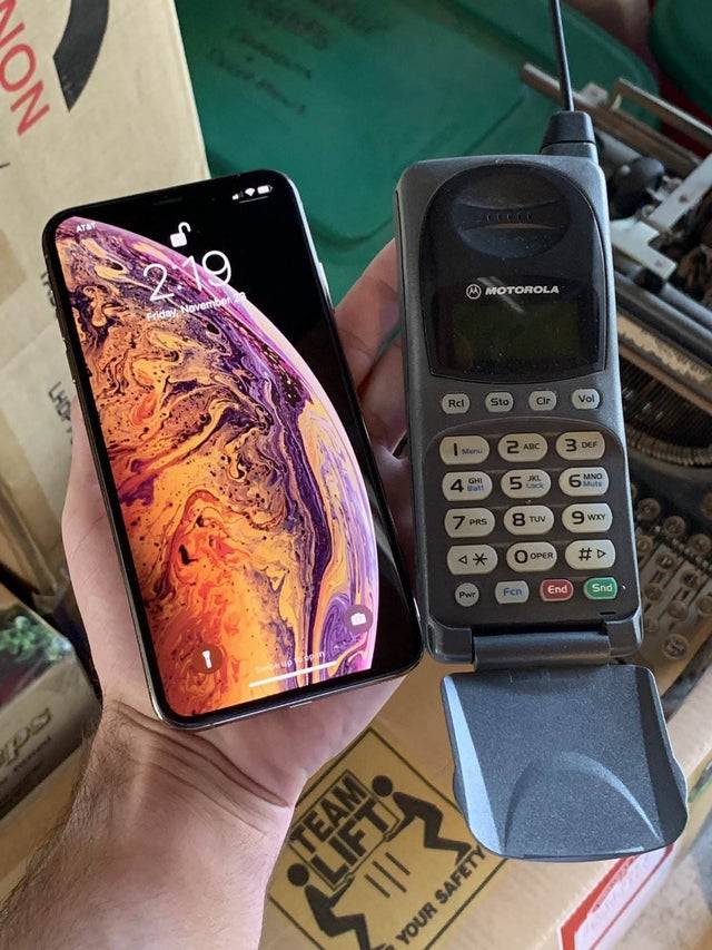 An iPhone beside a Motorola pocket phone from 1998