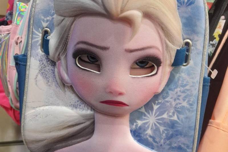 Elsa with sad eyes on backpack