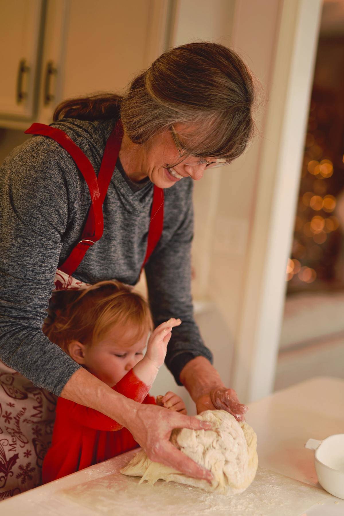 Grandmother bakes bread with young granddaughter