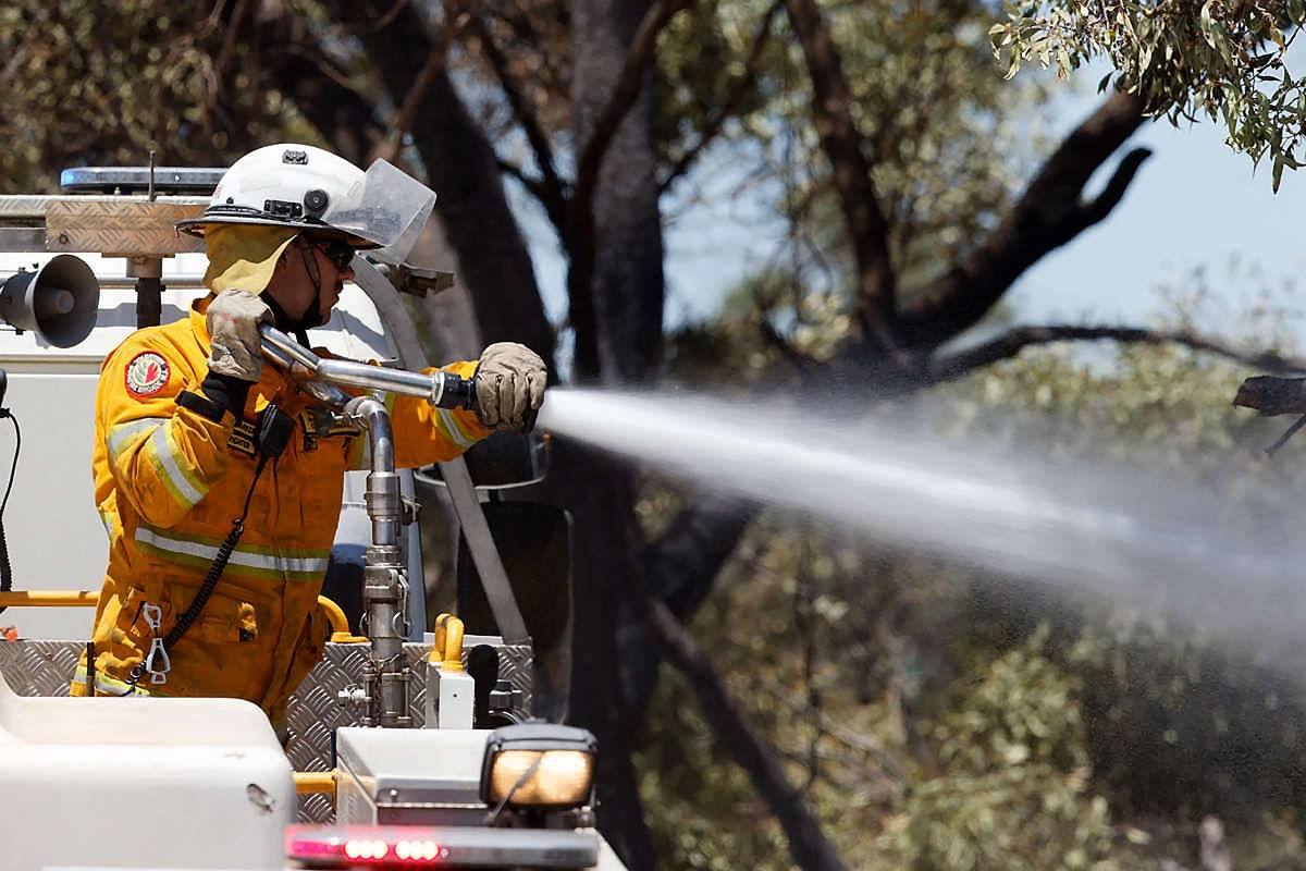 firefighter spraying hose from top of truck