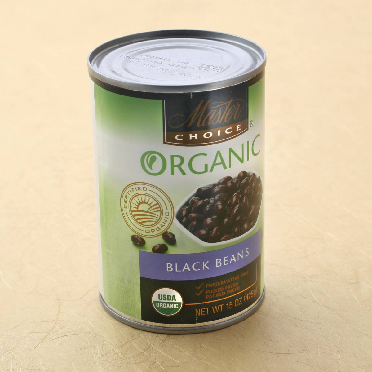 A can of black beans is on a table.