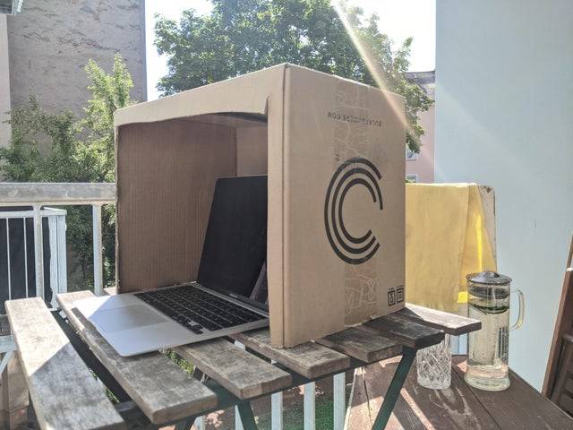 laptop with box over it to act as sun shade