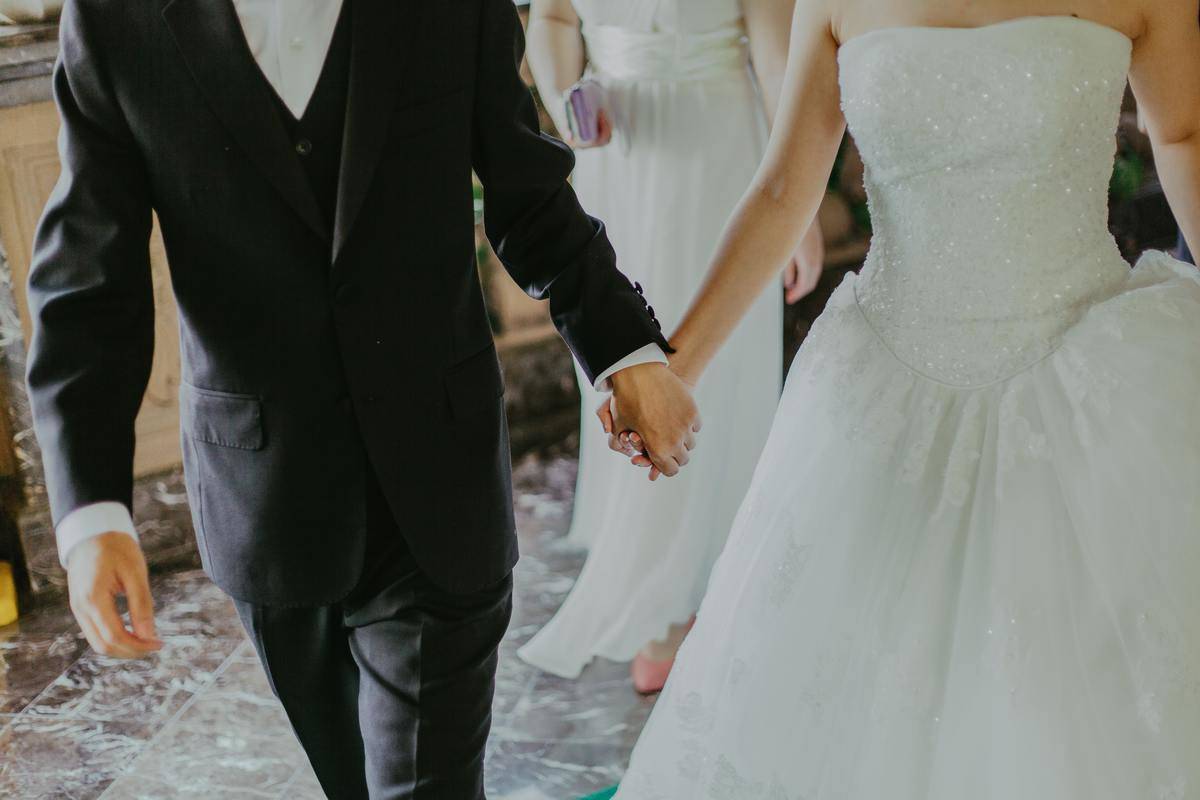 bride and groom holding hands while walking
