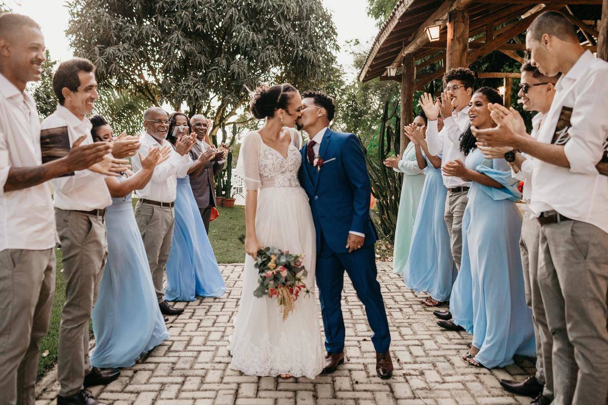 bride and groom standing on pathway surrounded by guests