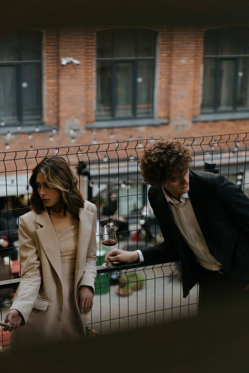 a man and woman standing together looking away from each other