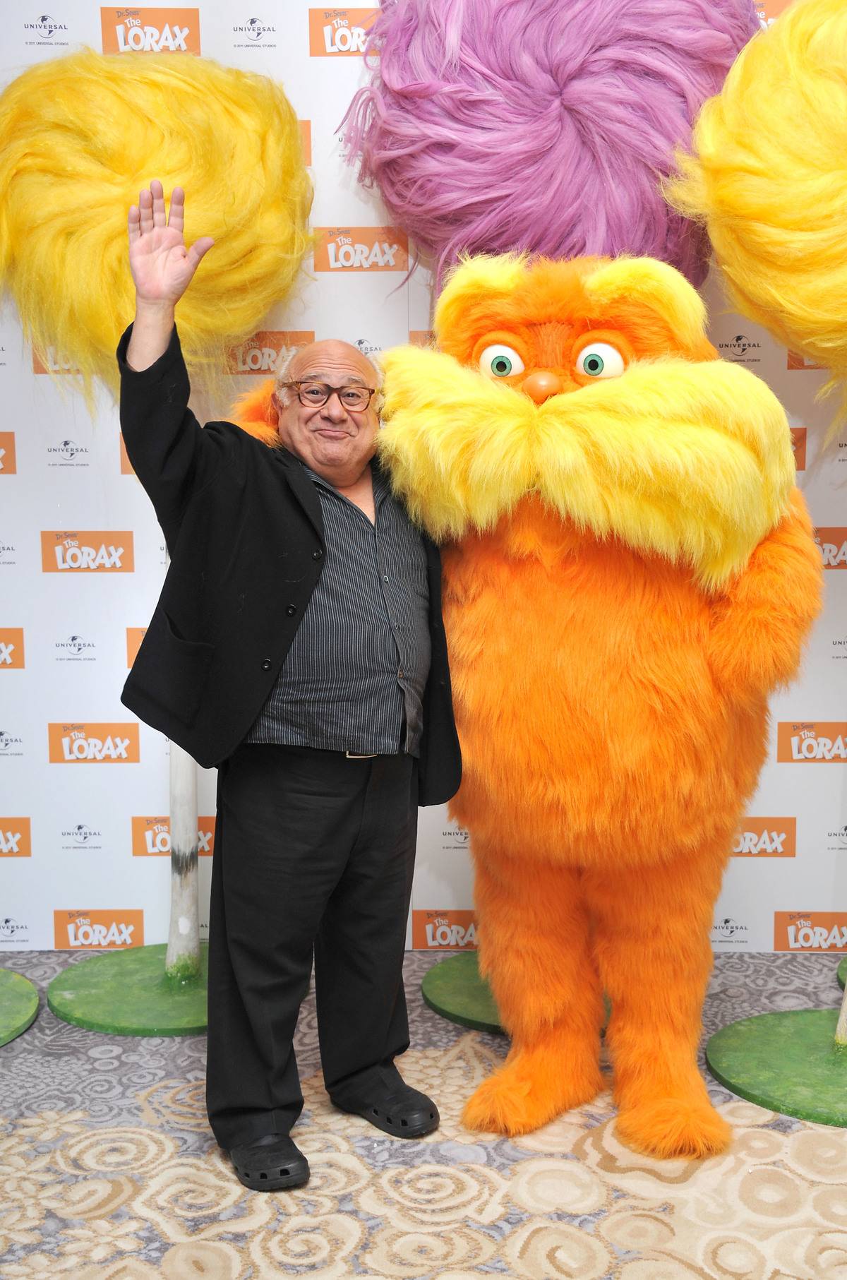 Danny DeVito posing with lorax at film premiere
