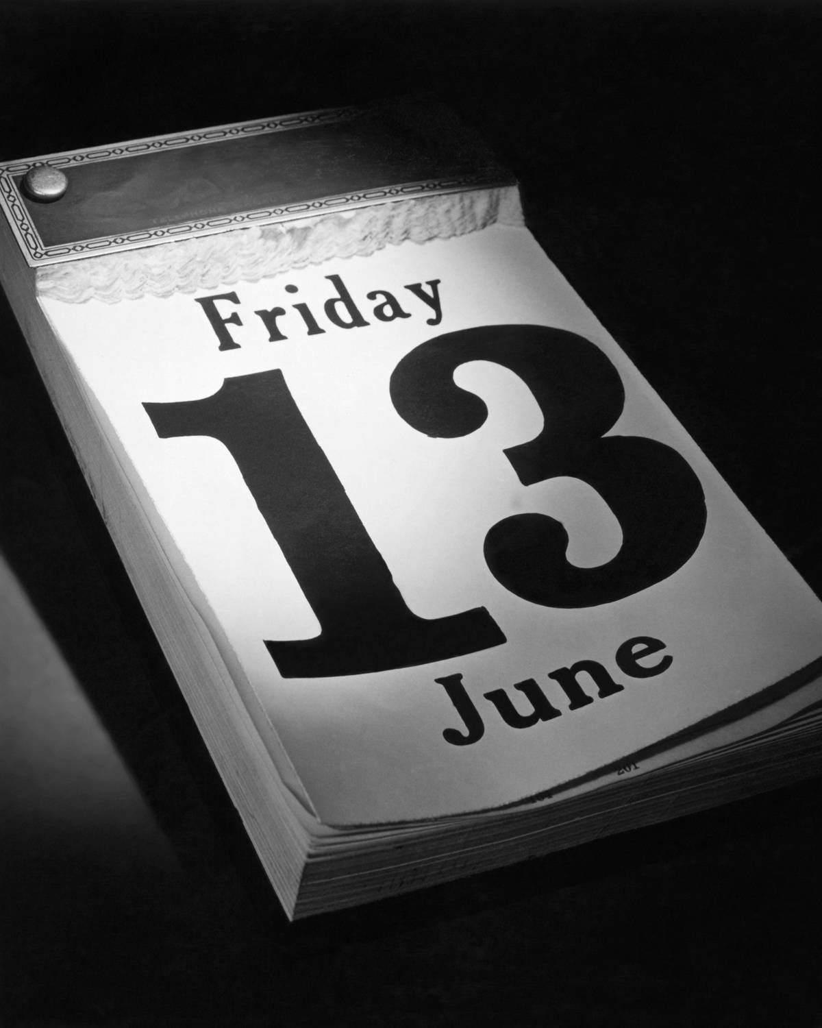 Closeup of a desk calendar with the date Friday, June 13th exposed.
