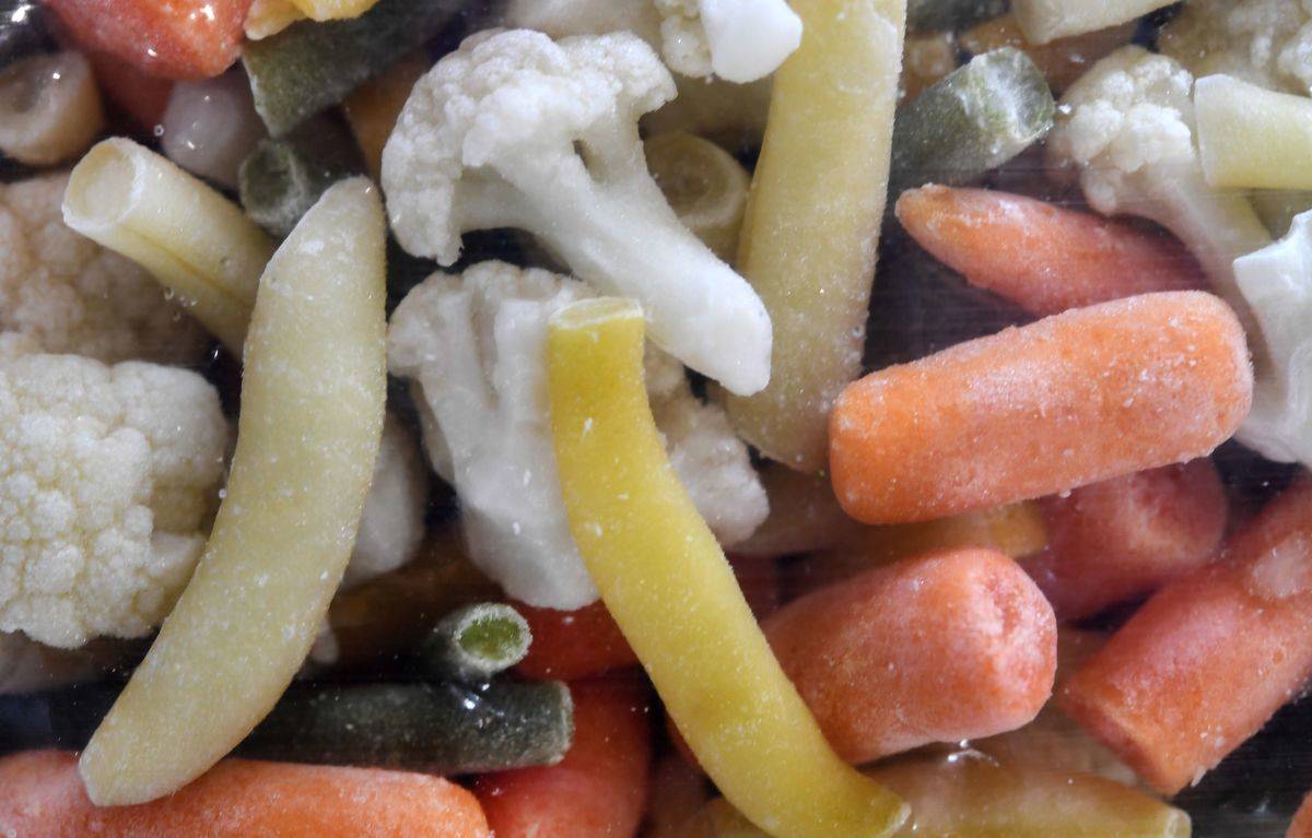 Frozen carrots, peas, and cauliflower lie in a pile