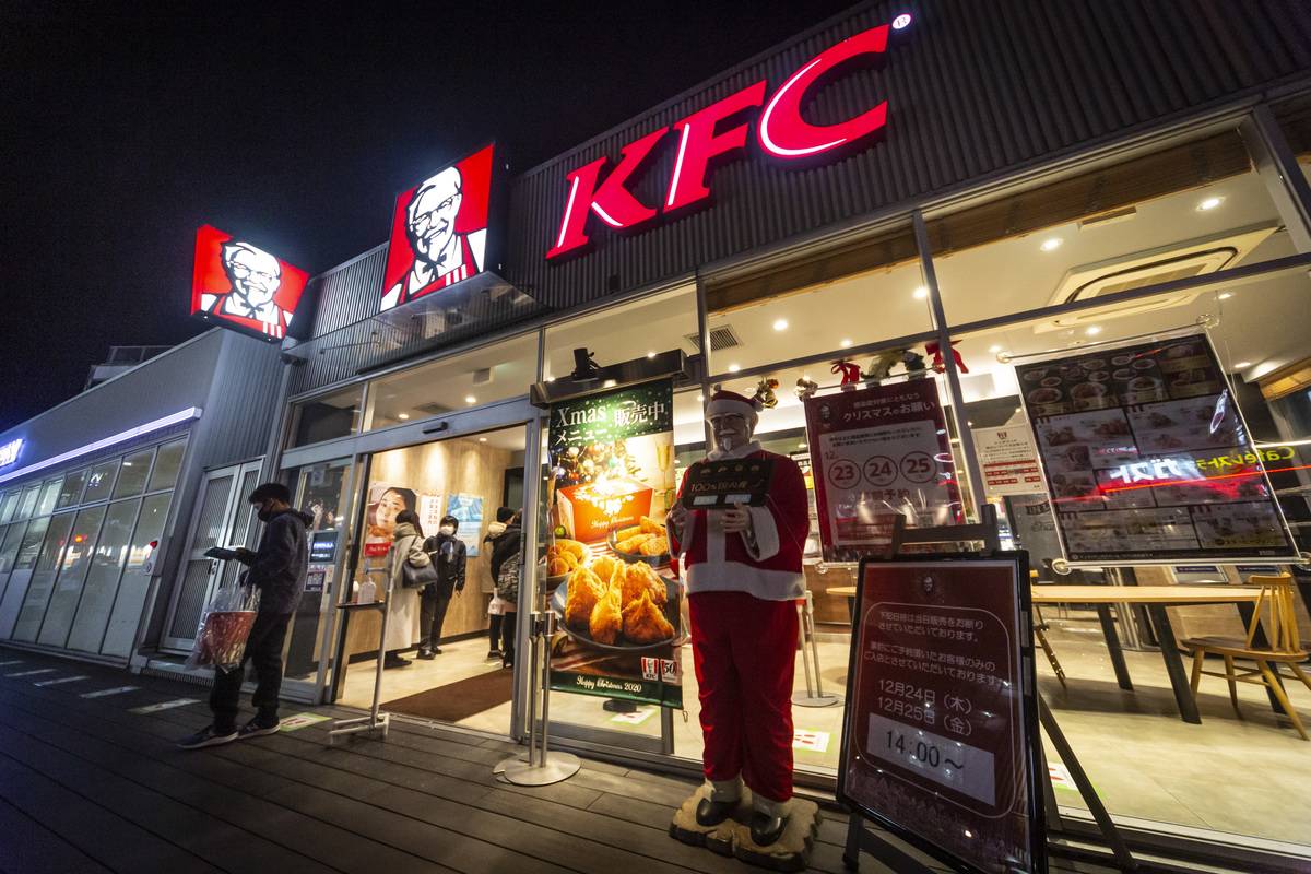 A man holding a Christmas meal box leaves a KFC restaurant on December 23, 2020 in Tokyo, Japan