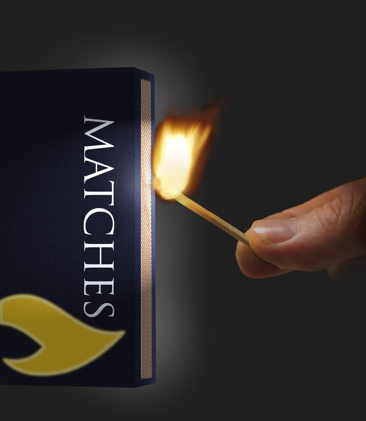 View of a hand striking a match to light a fire, 2003. United States.
