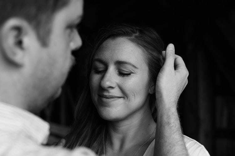 man tucking hair behind woman's ear