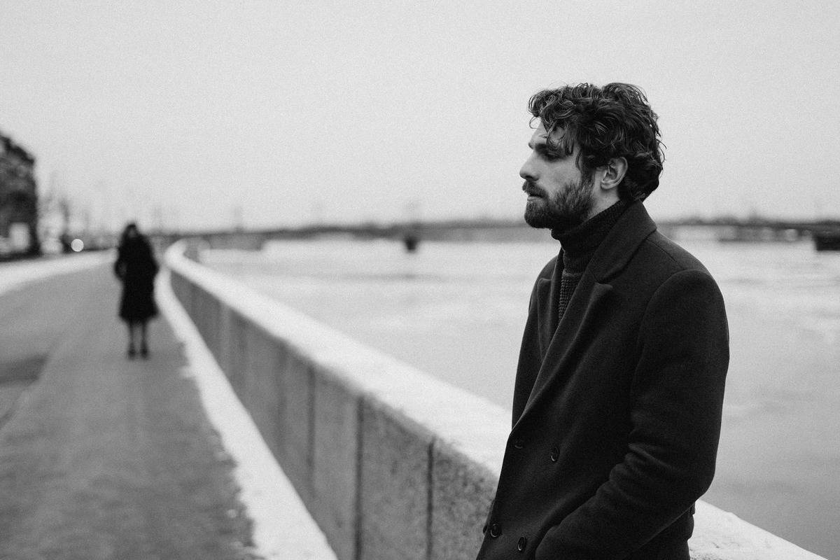 black-and-white photo of bearded man reflecting