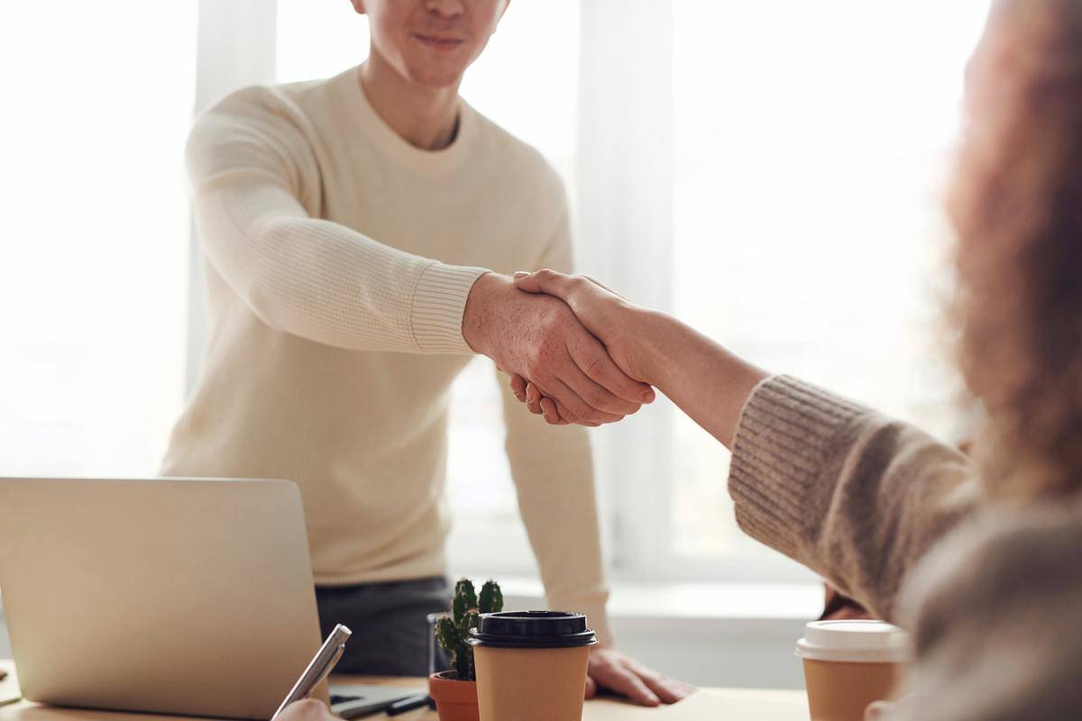 man shaking hands with woman