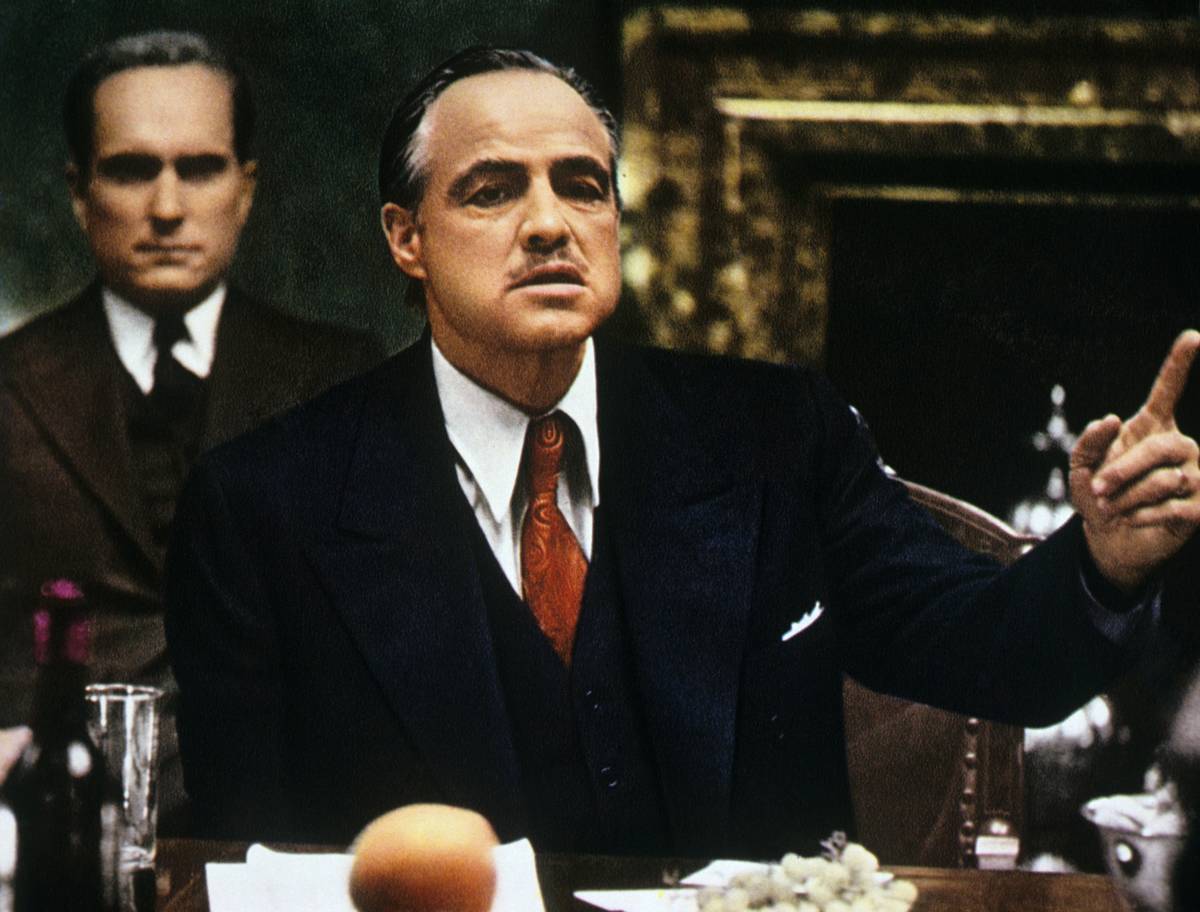 American actor Marlon Brando sitting at the table and talking in The Godfather.