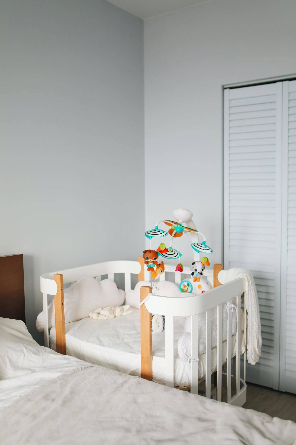 nursery with white crib with colorful mobile hanging