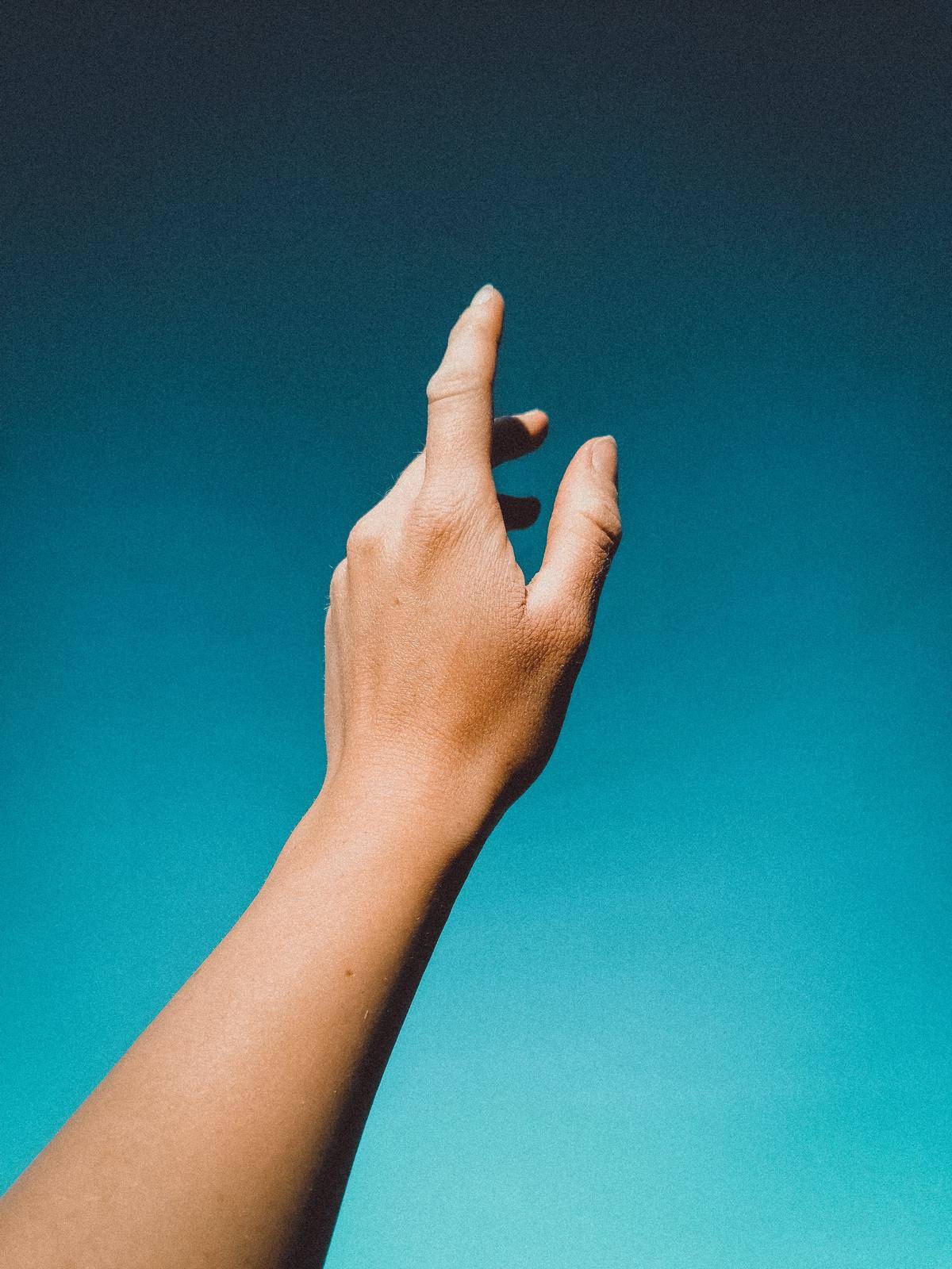 A woman's hand reaches upward.