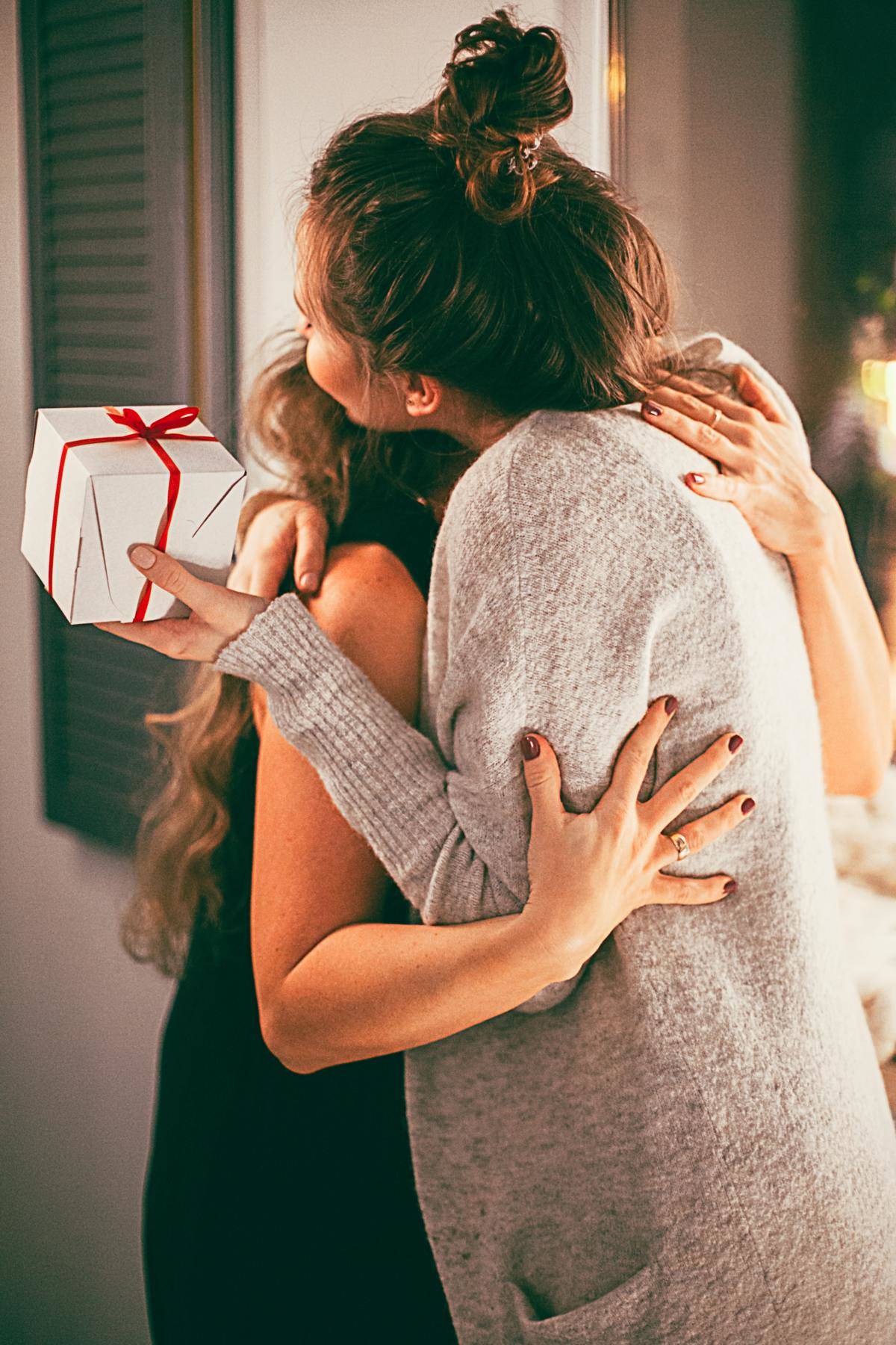 two women hugging with a gift