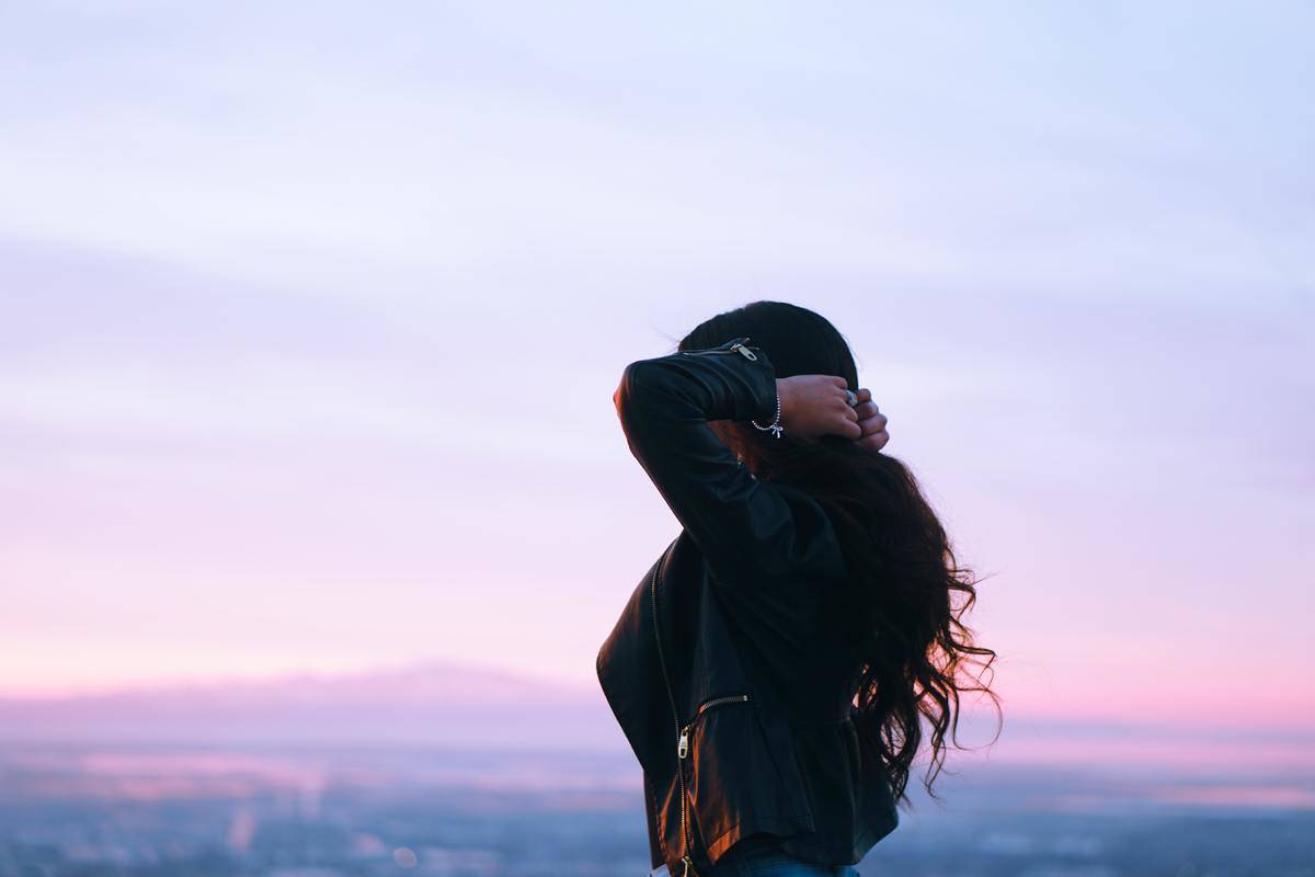 woman at sunset holding her hair