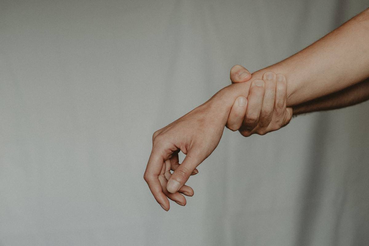 People's arms; one grabbing the other by the wrist
