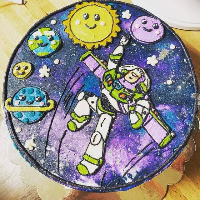 A pretty cake that's been decorated to include Buzz Lightyear and the galaxy