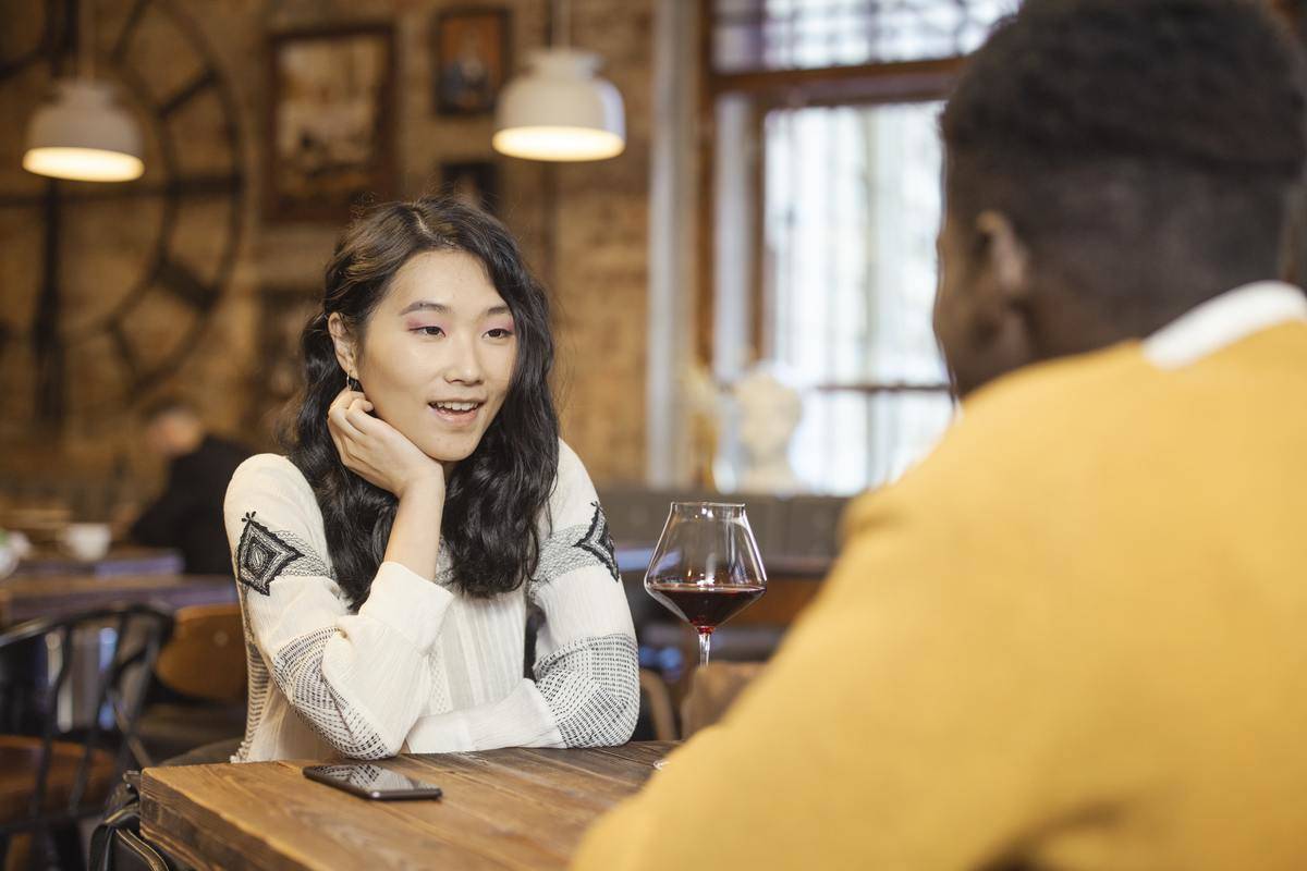 Young woman smiles across the table at her date
