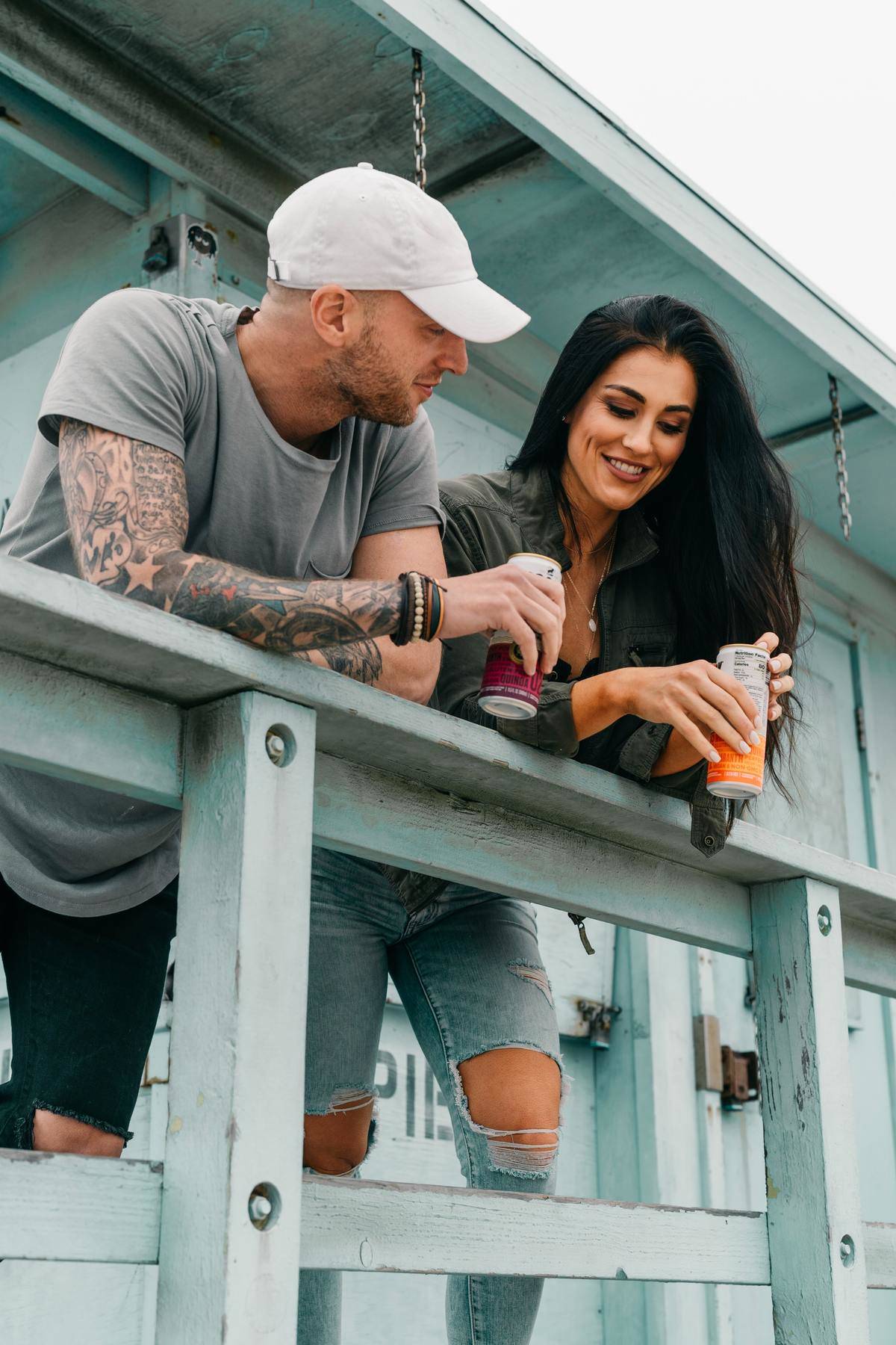 Man and woman holding drinks standing on deck