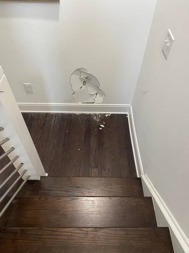 Damaged wall at the bottom of the stairs because someone went headfirst into it